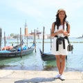 Papuan girl in front of gondolas in harbor in Venice