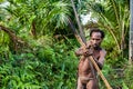 The Papuan from a Korowai tribe aims for shoots an archer. Korowai kombai (Kolufo) with bow and arrows Royalty Free Stock Photo