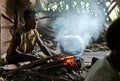 Papuan woman cooks food. Royalty Free Stock Photo