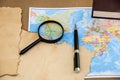 Papyrus on a world map, pen and magnifier Royalty Free Stock Photo