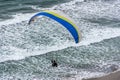 Paraglider gliding over an ocean view.