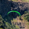 Para glider soars over the beach waves and hills at Murawai Beach Auckland New Zealand Royalty Free Stock Photo