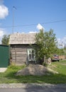 PARABEL, RUSSIA - AUGUST 1, 2023. A street with an old wooden house with an antenna and a car
