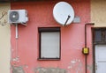 Parabolic antenna and air conditioner on the wall of an old building