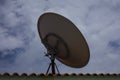 Parabolic dish antenna held on the roof top of a building. Dish is used by consumers to receive direct-broadcast satellite televi