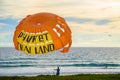 Parachute with an inscription Phuket Thailand on the seashore in the evening.