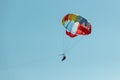 With a parachute for parasailing a couple flies through the air with blue sky in the background. Royalty Free Stock Photo