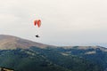 parachute skydiver flying in clouds at mountains, travel adventure concept, space for text