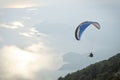 Parachute skydiver flying in clouds at top of mountains