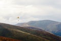 Parachute skydiver flying in clouds at top of mountains with ama