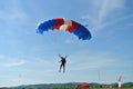 Parachuter, skydiver jumping and skydiving with blue red white colours parachute on parachuting cup, extreme sport