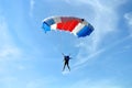 Parachuter, skydiver jumping and skydiving with blue white red colours parachute on parachuting cup, extreme sport