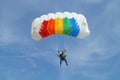 Parachuter, skydiver jumping and skydiving with colorful parachute in rainbow colours on parachuting cup, extreme sport