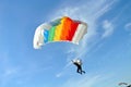 Parachuter, skydiver jumping and skydiving with colorful parachute in rainbow colours on parachuting cup, extreme sport