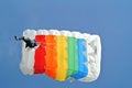 Parachuter, skydiver jumping and skydiving with colorful parachute in rainbow colours on parachuting cup, extreme sport