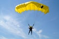 Parachuter, skydiver jumping and skydiving with parachute of yellow color on parachuting competition, extreme sport