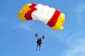 Parachuter, skydiver jumping and skydiving with yellow red white colours parachute on parachuting cup, extreme sport