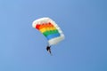 Parachuter skydiving with colourful parachute in rainbow colours on parachuting cup