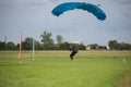 Parachutist with Blue Parachute near to the Ground Preparing for Landing Royalty Free Stock Photo