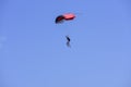 Parachutist descends into the blue sky on a sunny day