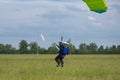 Parachutist with Green Parachute near to the Ground Preparing for Landing Royalty Free Stock Photo