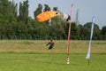 Parachutist with Orange Parachute near to the Ground Preparing for Landing Royalty Free Stock Photo