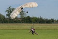 Parachutist with White Parachute near to the Ground Preparing for Landing.