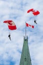 Parachutists glide by the Peace Tower at Parliament Hill in Ottawa on Canada Day