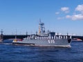 The parade of naval technology. Gray warship with sailors in formal white uniform on board against the background of the