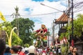 Parade on the street of Bali island. People carry a huge statue of a four-armed demon