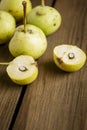 Paradise apples lie on a wooden table. A cut pear next to the whole one. Apple-pear on the table. Small pears a lot Royalty Free Stock Photo