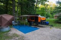 Paradise, MI - August 9, 2023: An orange and black Hiker teardrop camper parked in at a State Park