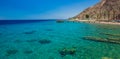 Paradise Red sea Israeli coral beach tropic scenery landscape with pier above water and fun people, summer season vacation Royalty Free Stock Photo