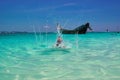 Paradise seascape. Little boy splashing in turquoise water warm tropical sea on sunny day against blue sky and fishing boat. Royalty Free Stock Photo