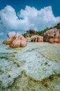 Paradise tropical beach Anse Source d`Argent with shallow blue lagoon, granite boulders and white clouds above. La Digue Royalty Free Stock Photo