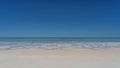 A paradisiacal minimalistic seascape. Sandy beach, aquamarine ocean, clear blue sky. Royalty Free Stock Photo