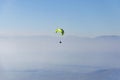 Paraglide silhouette above the misty valley