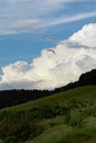 Paraglider flying over mountains in summer day