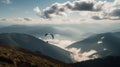 Paraglide silhouette flying over Carpathian peaks and clouds