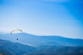 Paraglide silhouette flying over mountain peaks, mountain valley on background Royalty Free Stock Photo