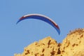 Paraglider blue sky and yellow sandstone cliff