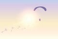 Paraglider flies with dandelion seeds in sunny sky