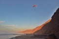 The paraglider flies over the coast at sunset. Royalty Free Stock Photo