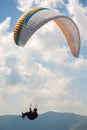 Paraglider flies over a mountain valley on a sunny summer day. Royalty Free Stock Photo