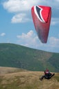 Paraglider flies over a mountain valley on a sunny summer day. Paragliding in the Carpathians in the summer. Royalty Free Stock Photo