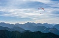 Paraglider flying above blue Mountains Silhouette, Allgaeu, Oberstdorf, Alps, Germany. Travel destination. Freedom and Royalty Free Stock Photo