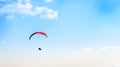 Paraglider flying against the blue sky with white clouds. Royalty Free Stock Photo