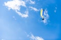 Paraglider flying against the blue sky with white clouds. Royalty Free Stock Photo