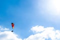 Paraglider flying against the blue sky with white clouds Royalty Free Stock Photo