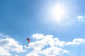 Paraglider flying against the blue sky with white clouds. Royalty Free Stock Photo